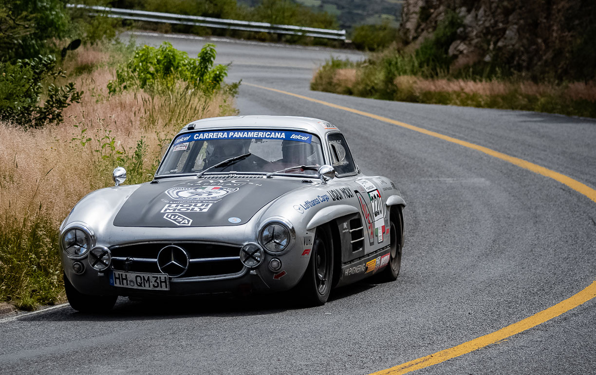 A Silver Grey Mercedesbenz 300sl Gullwing Racing On The Tracks